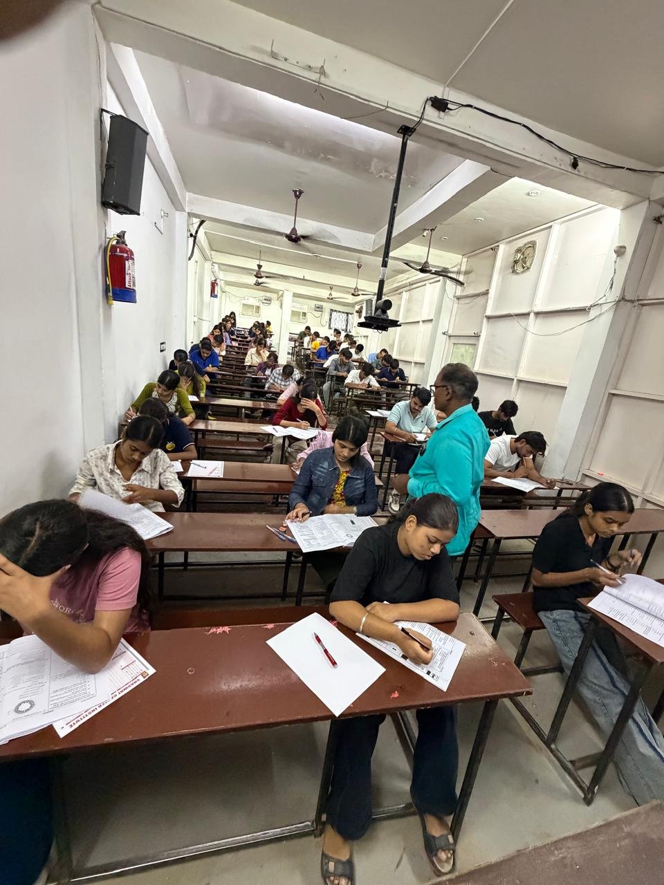 Portrait view of a staff member supervising students as they work
